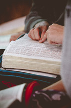 pointing to scripture while reading a Bible