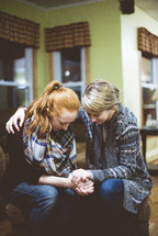 two women praying together 