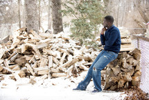 African American man sitting on a pile of wood 