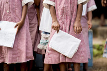 girls standing holding notebooks 