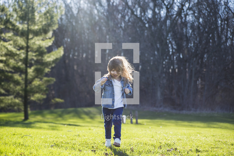 toddler girl running in grass 