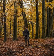 a man standing in a fall forest 