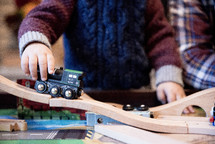 toddler playing with a train set 