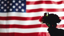 Flowers for memorial day. Silhouette of Usa Soldier holds flowers.