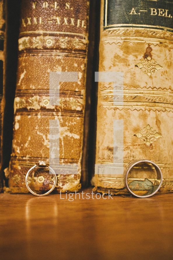 wedding rings leaning against old books