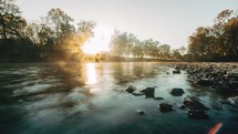 Time-lapse of the sun rising over a secluded misty river