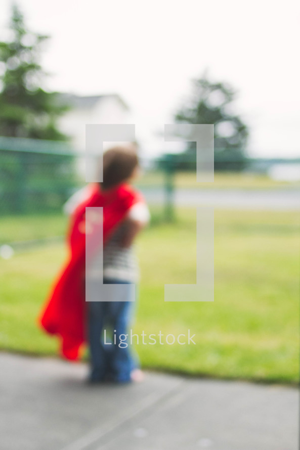 blurry image of a boy child in a cape 