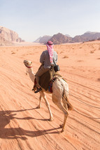 riding a camel through a desert 