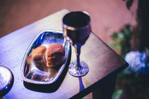 communion bread and wine in silver chalice and tray
