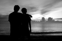 silhouettes of brothers on a beach 