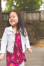 a smiling toddler girl outdoors 