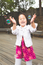 a girl child playing with bubbles 