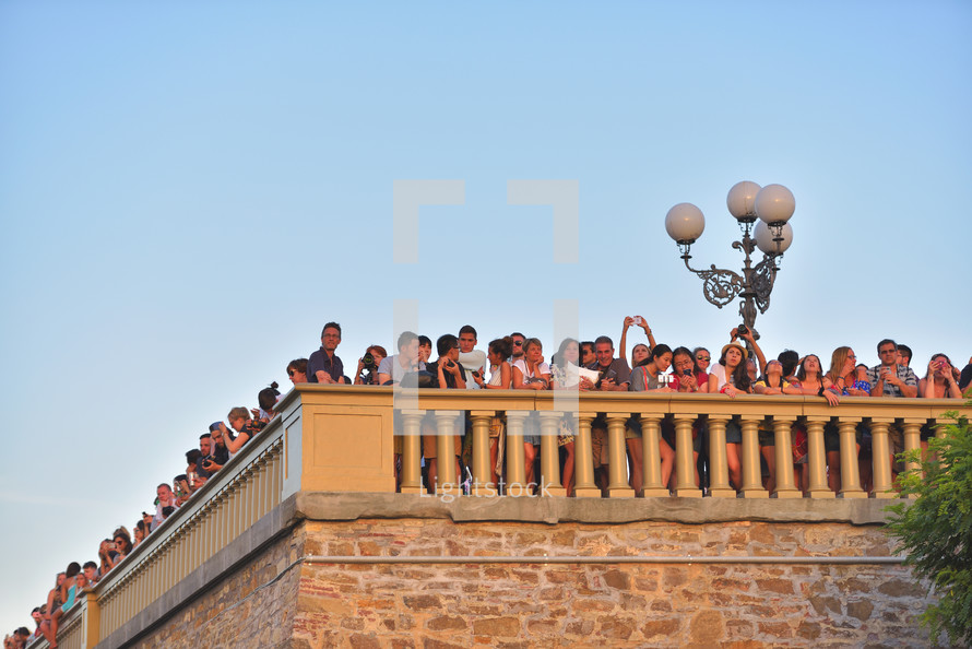 Tourists sightseeing over Florence from Piazzale Michelangelo at sunset