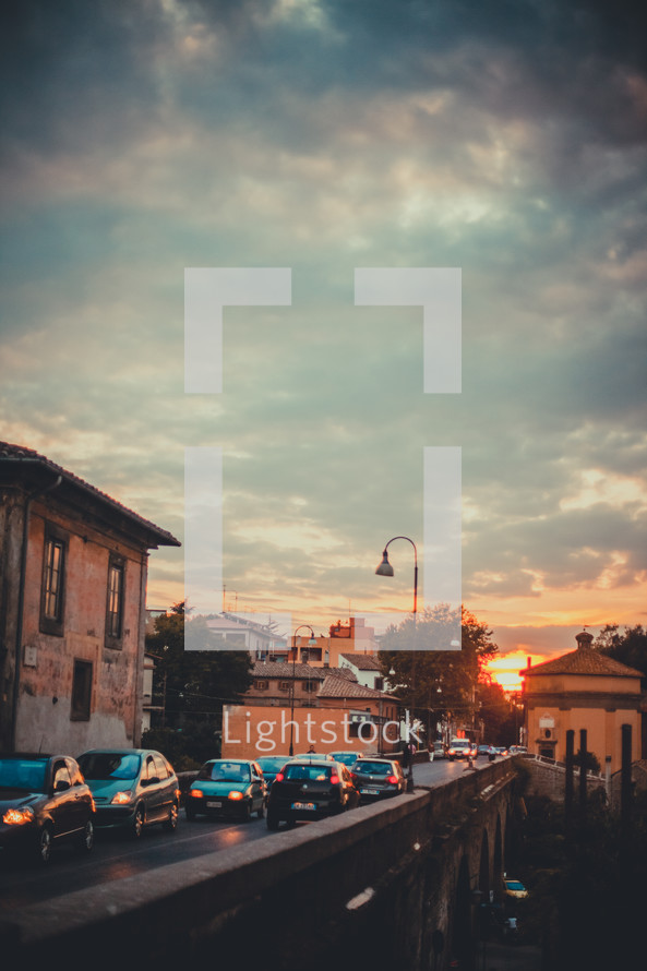 cars on the road in a European town at sunset 