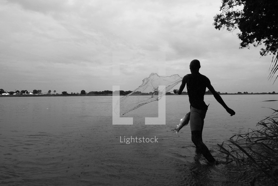 Southern Sudanese fisherman casting his net on the banks of the River Nile. 