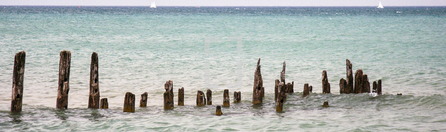 A row wood post on an ocean shore