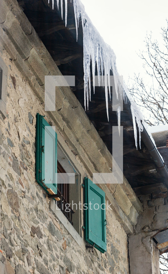 icicles on a the roof of a house 