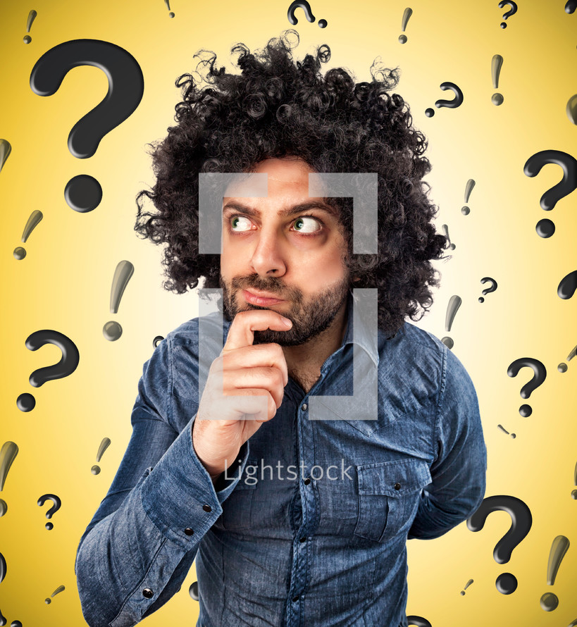 man thinks about something on background with question marks and exclamation marks
