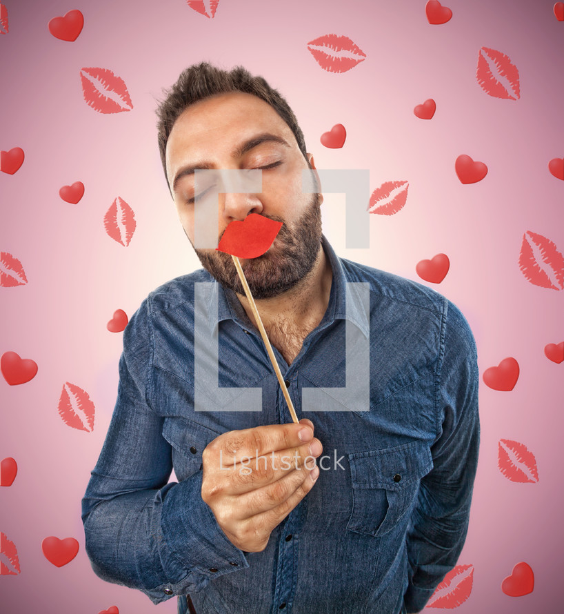 man with photo booth shaped lips and background with kisses and hearts