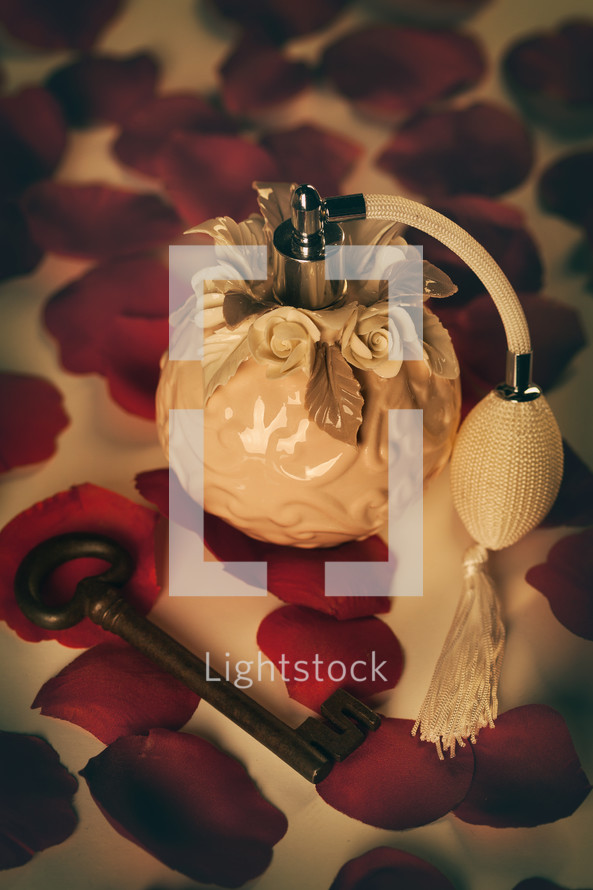 Perfume bottle on red rose petals, concept of love and passion.