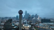 Reunion Tower in Dallas, Texas with the skyline behind it on a cloudy/gloomy morning.