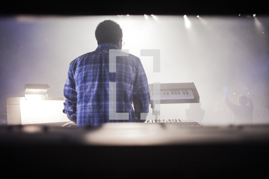 A shot from behind of a keyboardist during corporate worship