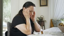Woman suffering from migraine headache using cannabis oil for relief from pain