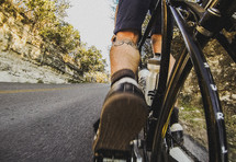 Feet and legs of biker biking uphill.