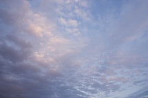 soft sunrise clouds in pink, gray, purple with blue sky