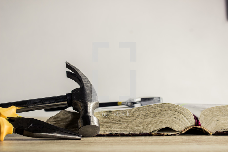 tools, open Bible, and cross 
