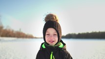 Winter time, happiness childhood. Happy boy play in a beautiful winter park. Cute kid having fun at winter holidays. Healthy lifestyle concept.