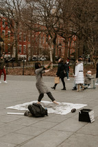Woman dancing while painting in Washington Square Park
