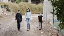 Coronavirus pandemic - kids walking outdoors with face masks