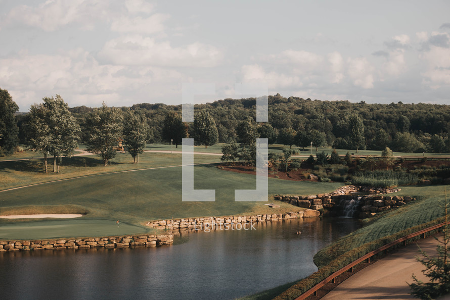 a wide view of a beautiful golf course with a lake