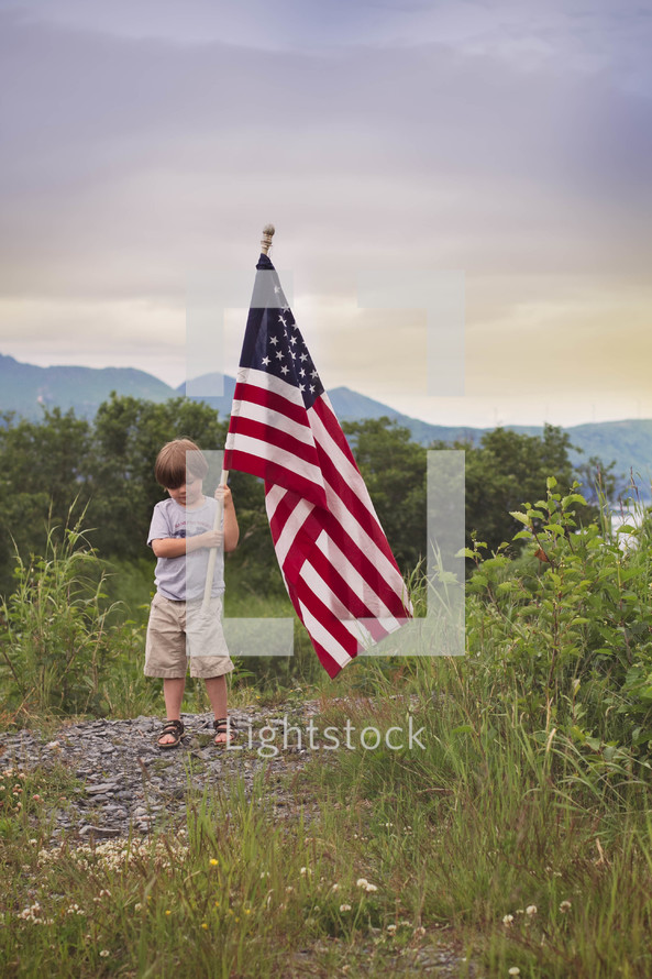 boy child carrying an American flag 