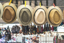 hats and bags on clotheslines in a market 