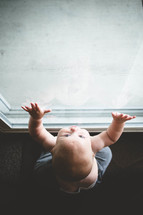 infant looking out a window 