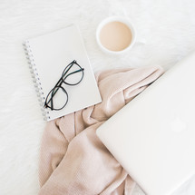 laptop computer, reading glasses, and journal on a blanket 