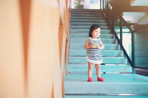 toddler girl standing on stairs 