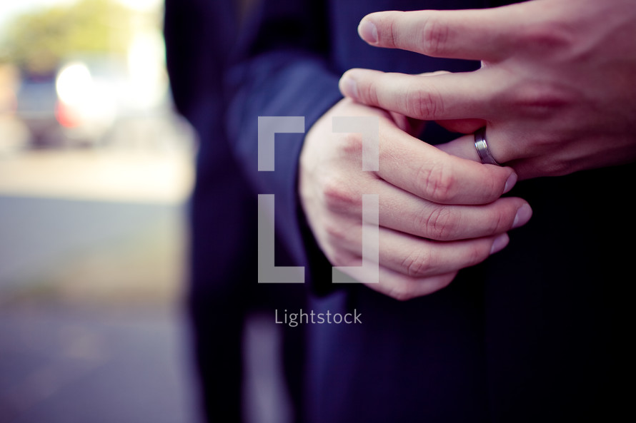 man with his hands on his wedding band