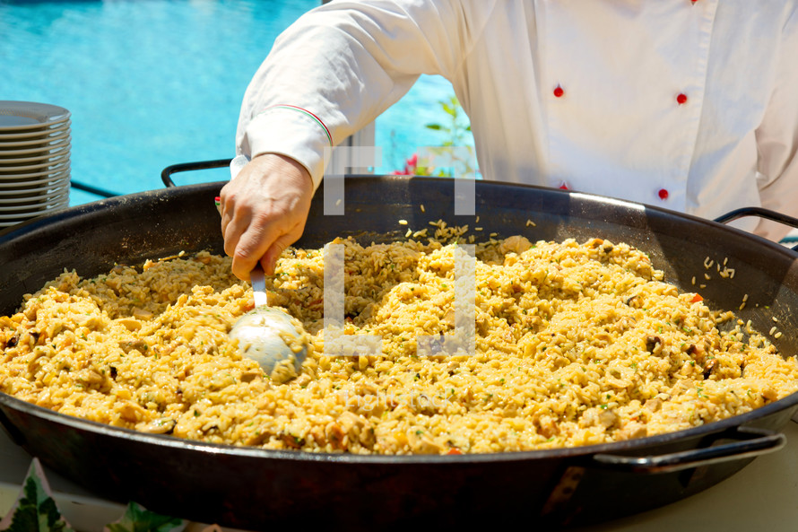 Cooking paella at an outdoor restaurant for a wedding banquet.