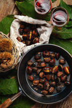  Roasted chestnuts in iron skillet on wooden table