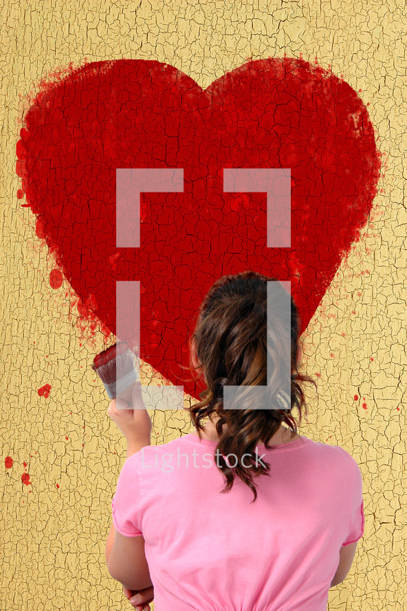 woman painting a red heart 