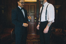 Two men in formal attire talking together.