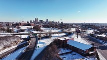 Aerial footage of Saint Louis, Missouri on a cold and snowy winter morning with clear blue skies and snow on the ground.