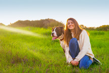 Young woman sitting with American Staffordshire terrier