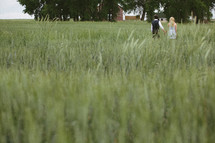 Couple walking in tall grass field