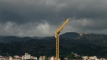 Yellow construction crane with cloudy sky