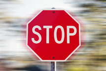 Stop sign against a fast-spinning background.