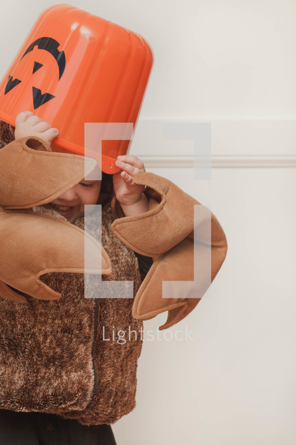 toddler boy in a halloween costume on candy bucket 